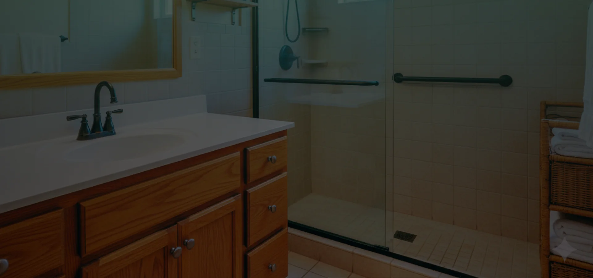 A bathroom, suitable for aging in place, with walk-in shower, grab bars, and oak vanity in a well-kept suburban home.