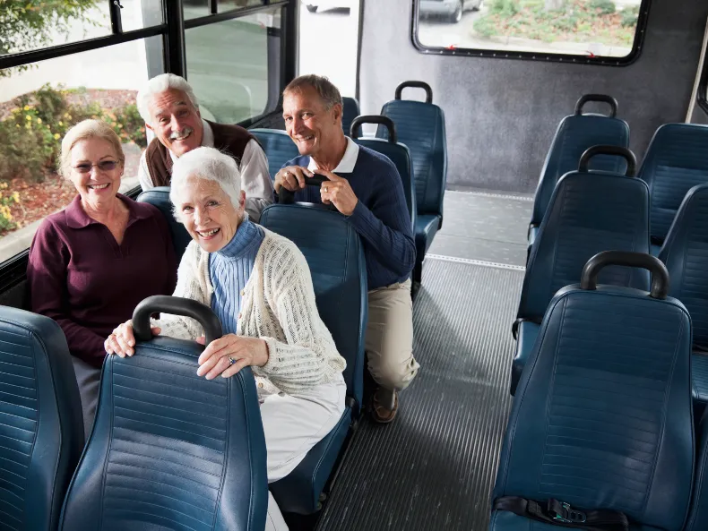 Seniors smiling on a group outing, showcasing vibrant community life.